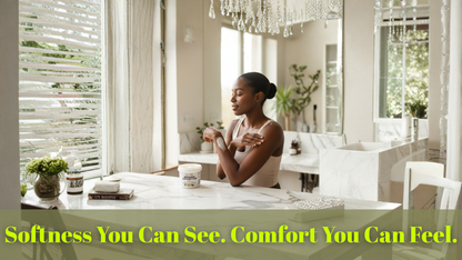 Woman sitting at a table in a bright, modern room with large windows and decorative elements.