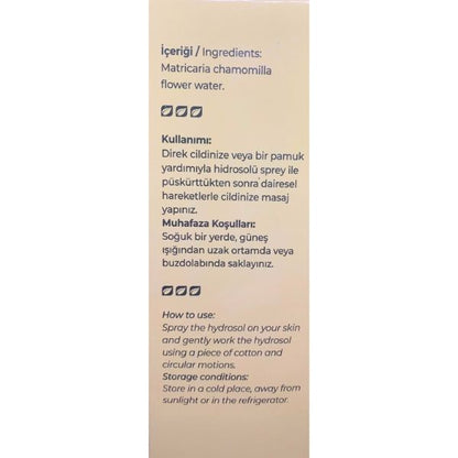 A vertical beige packaging card showing product details in Turkish and English, including ingredients (matricaria chamomille flower water) and usage instructions for a hydrogel spray.