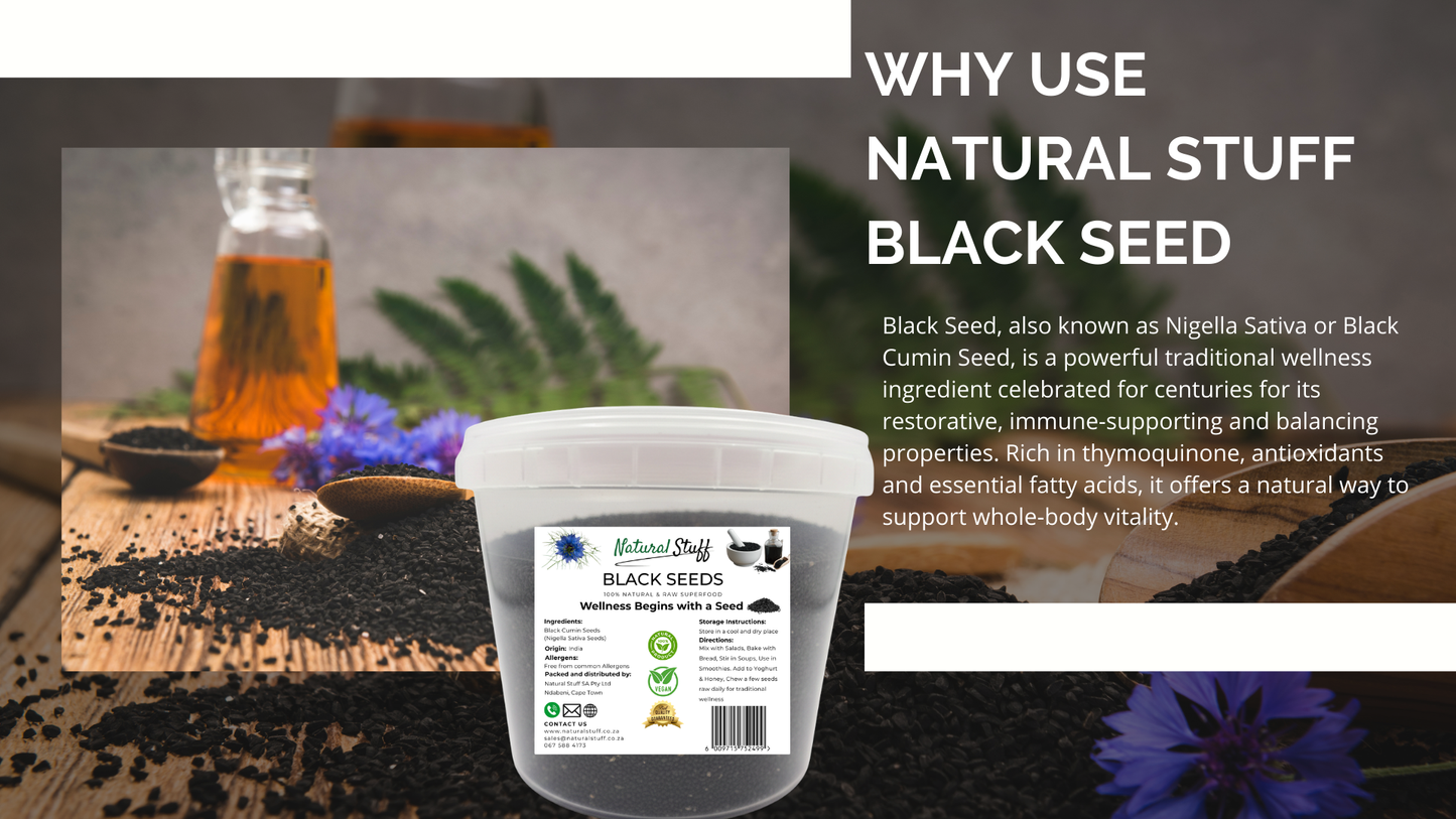 Container of Black Seed with a label on a wooden surface, surrounded by herbs and flowers.