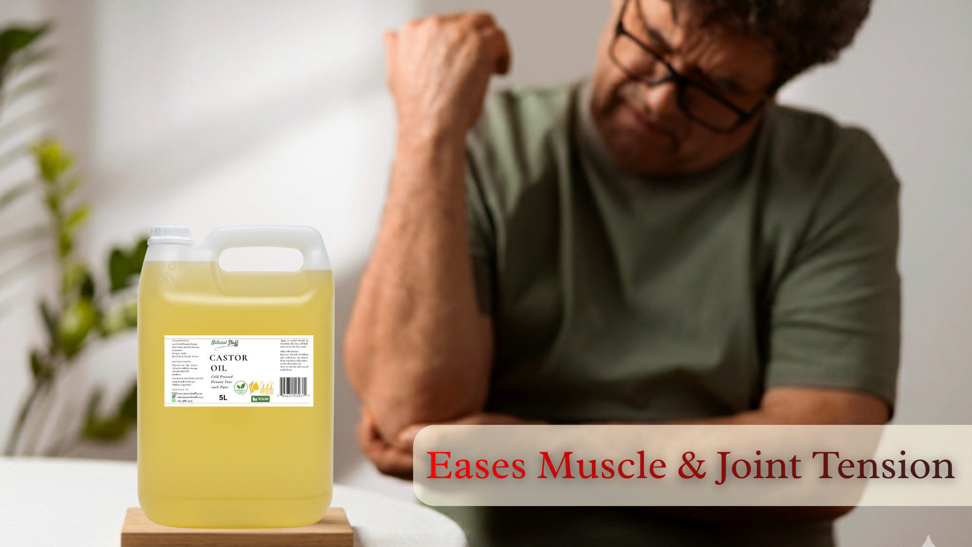 Person with a bottle of liquid labeled 'Eases Muscle & Joint Tension' on a table.