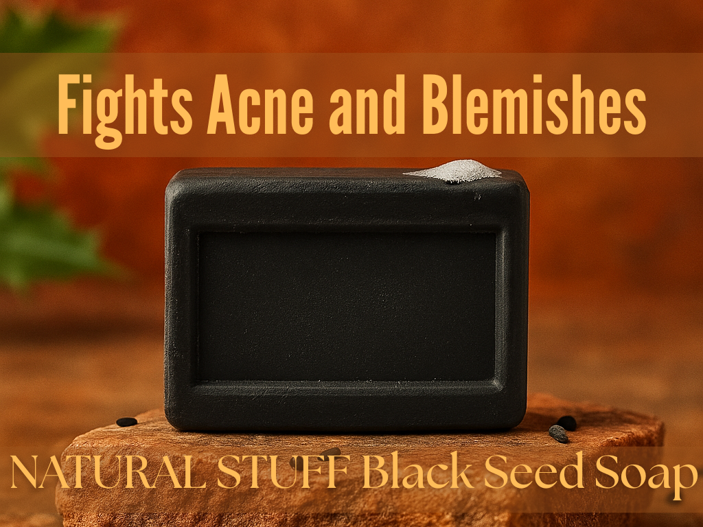 Black bar of soap on a wooden block with text 'Fights Acne and Blemishes' and 'NATURAL STUFF Black Seed Soap' on a brown background.