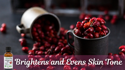Red berries in a cup with a bottle labeled 'Brightens and Evens Skin Tone' on a dark background