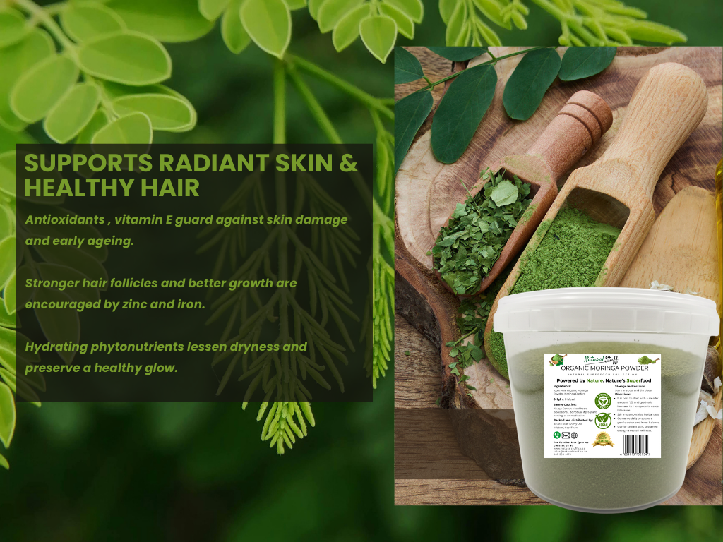 Green powder in a container with wooden scoops on a wooden surface, surrounded by green leaves.