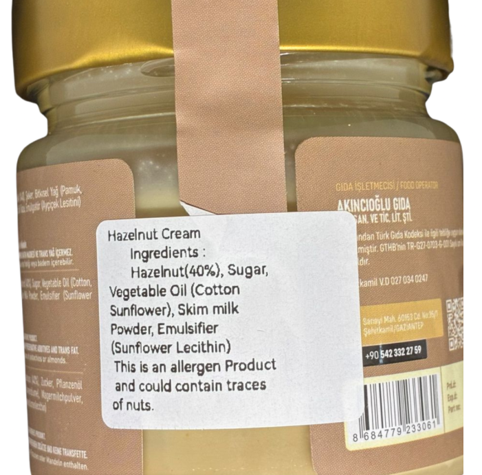 Jar of hazelnut cream with ingredient label and warning on a white background